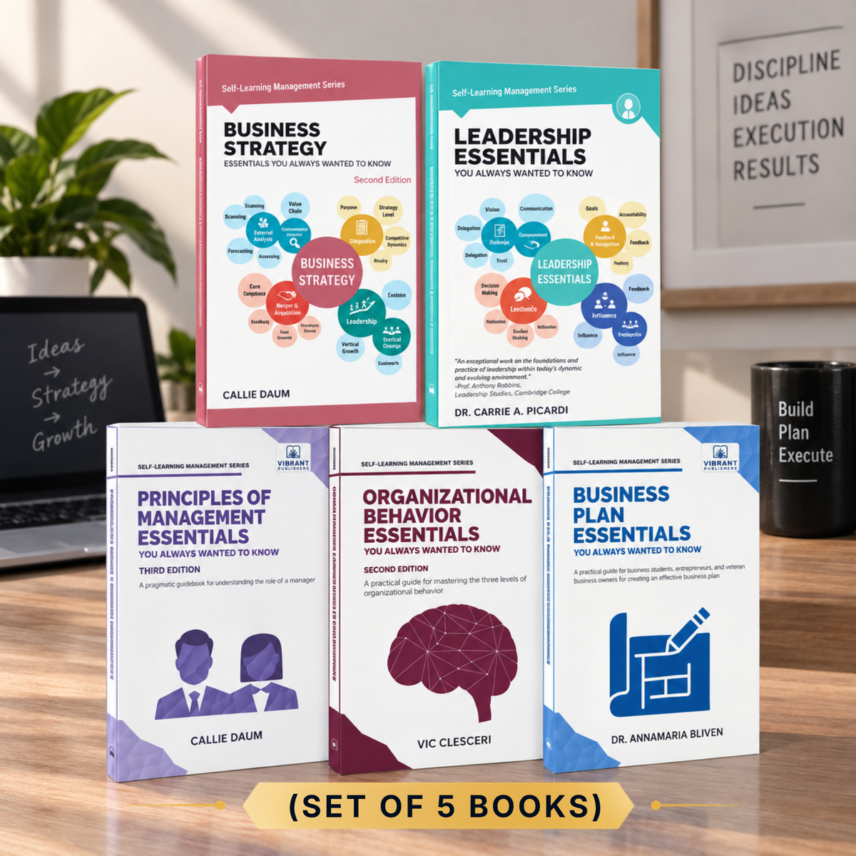 Five business books arranged on a wooden desk in a styled office setting. The books are: Business Strategy, Leadership Essentials, Principles of Management Essentials, Organizational Behavior Essentials, and Business Plan Essentials.