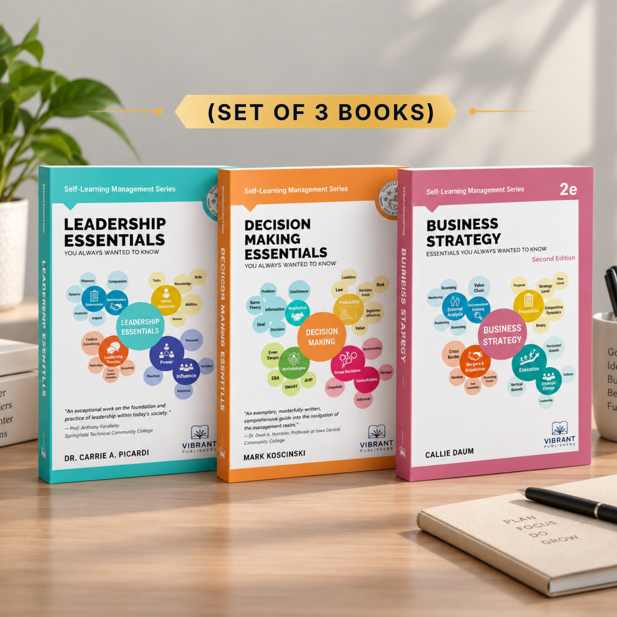 Three business books from the Vibrant publishers Management Series are displayed on a wooden desk: 'Leadership Essentials', 'Decision Making Essentials', and 'Business Strategy'. A yellow banner at the top reads '(SET OF 3 BOOKS)'.