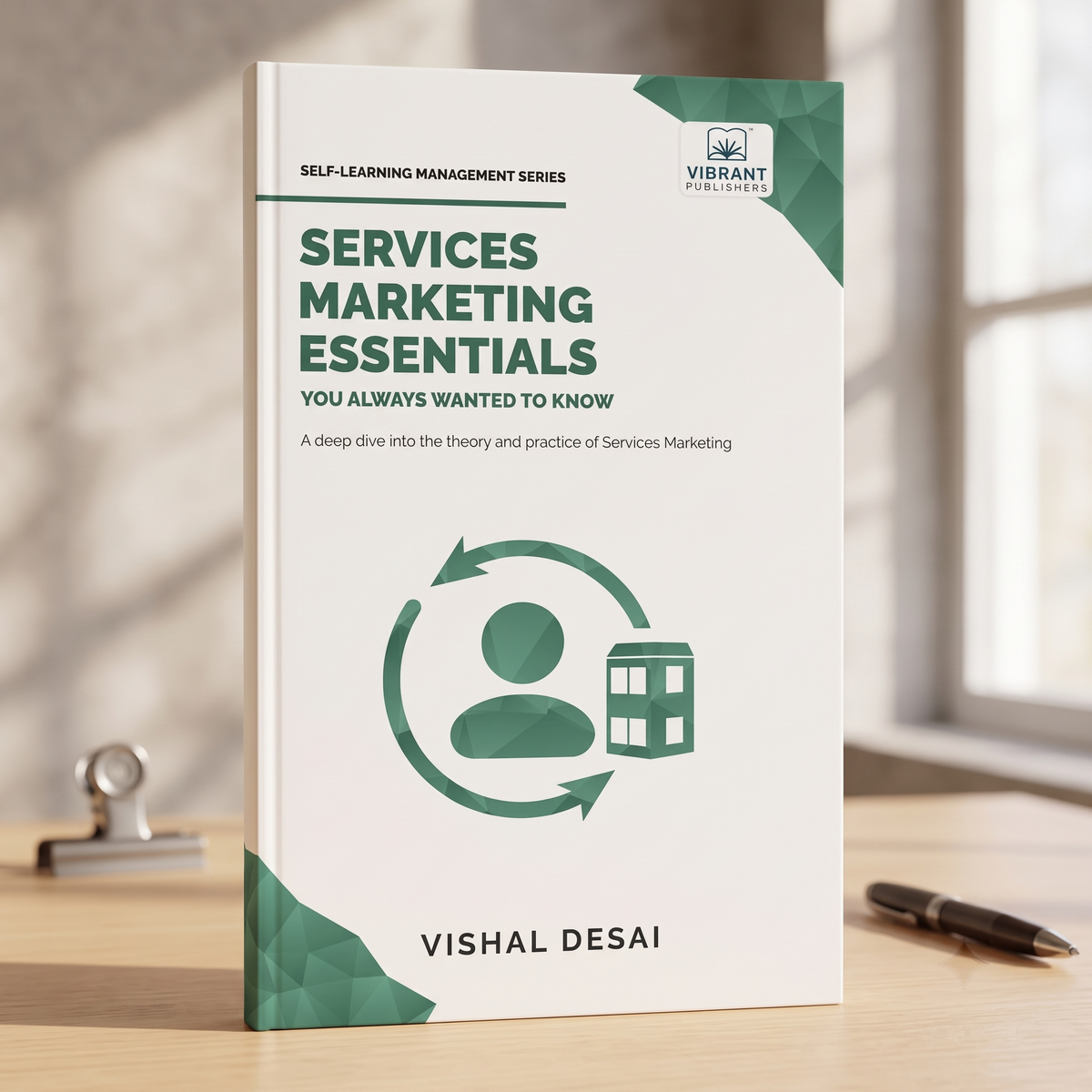 A book titled 'Services Marketing Essentials' by Vishal Desai, standing upright on a wooden desk. 